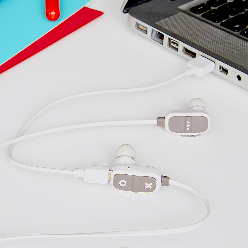 Jam Audio Live Large Wireless Bluetooth® Grey Earbuds plugged into laptop