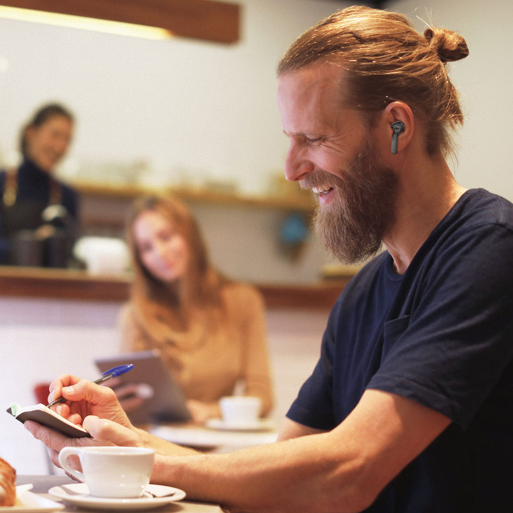 Man wearing Jam Audio ANC True Wireless Earphones Black in cafe