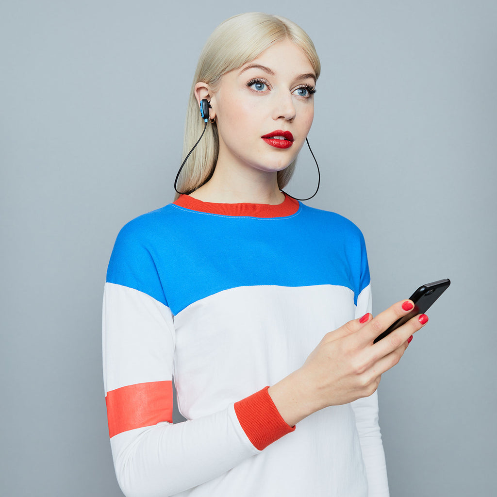 Woman wearing Jam Audio Live Large Wireless Bluetooth® Black Earbuds and holding phone
